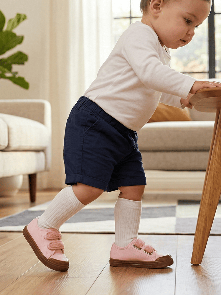 Piccola esploratrice che indossa le scarpe cotone per bimba durante i primi passi all'aperto.