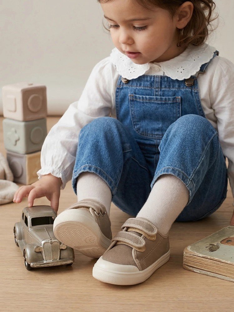 Un bambino che cammina all'aperto indossando le scarpine Dondi in cotone.