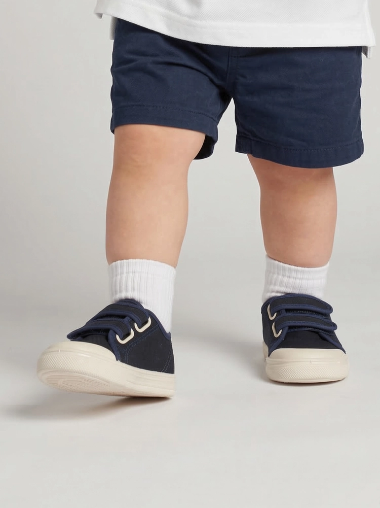 Un bambino che esplora l'ambiente indossando le scarpine Dondi navy.