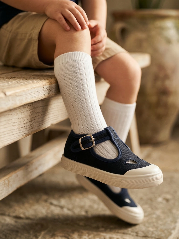 Un bambino che esplora l'ambiente indossando le scarpine Talpa blu navy.