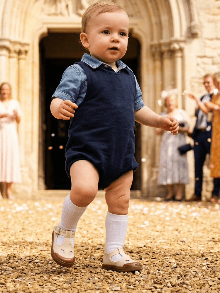 Bambino che cammina all'aperto con scarpe occhietti beige