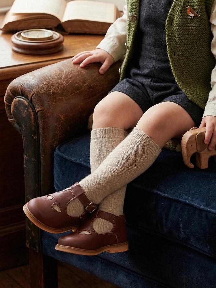 Scarpina occhietti in pelle marrone indossata da un bambino