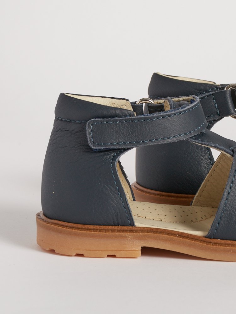 Dettaglio del tallone strutturato per il sostegno nel sandalo blu.