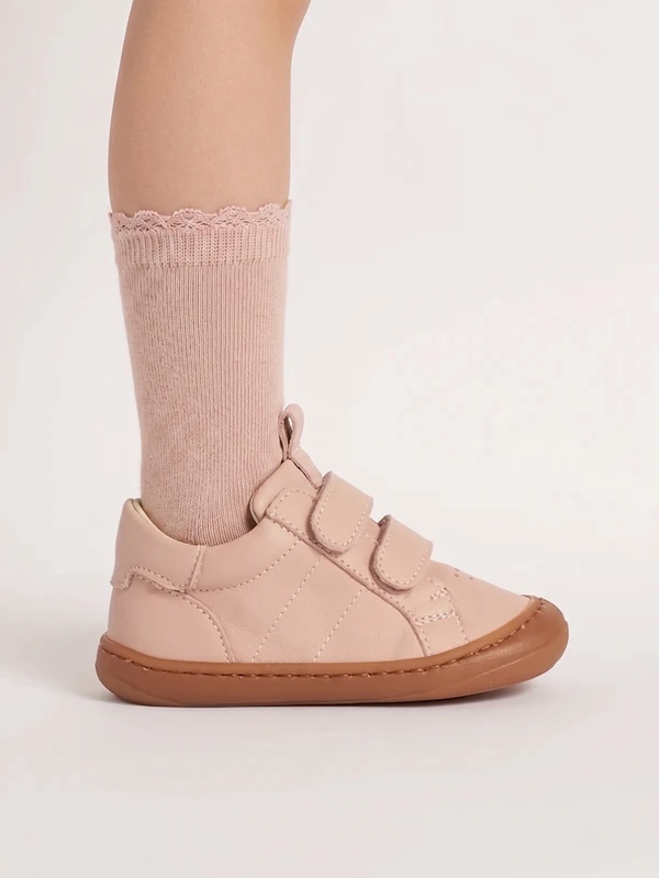scarpina primi passi per bambine rosa indossata su piedino con abbigliamento