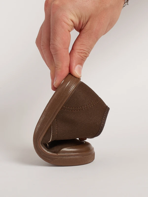 Dimostrazione della flessibilità e piegatura anatomica della suola drop zero nel polacchino classico per bambini marrone